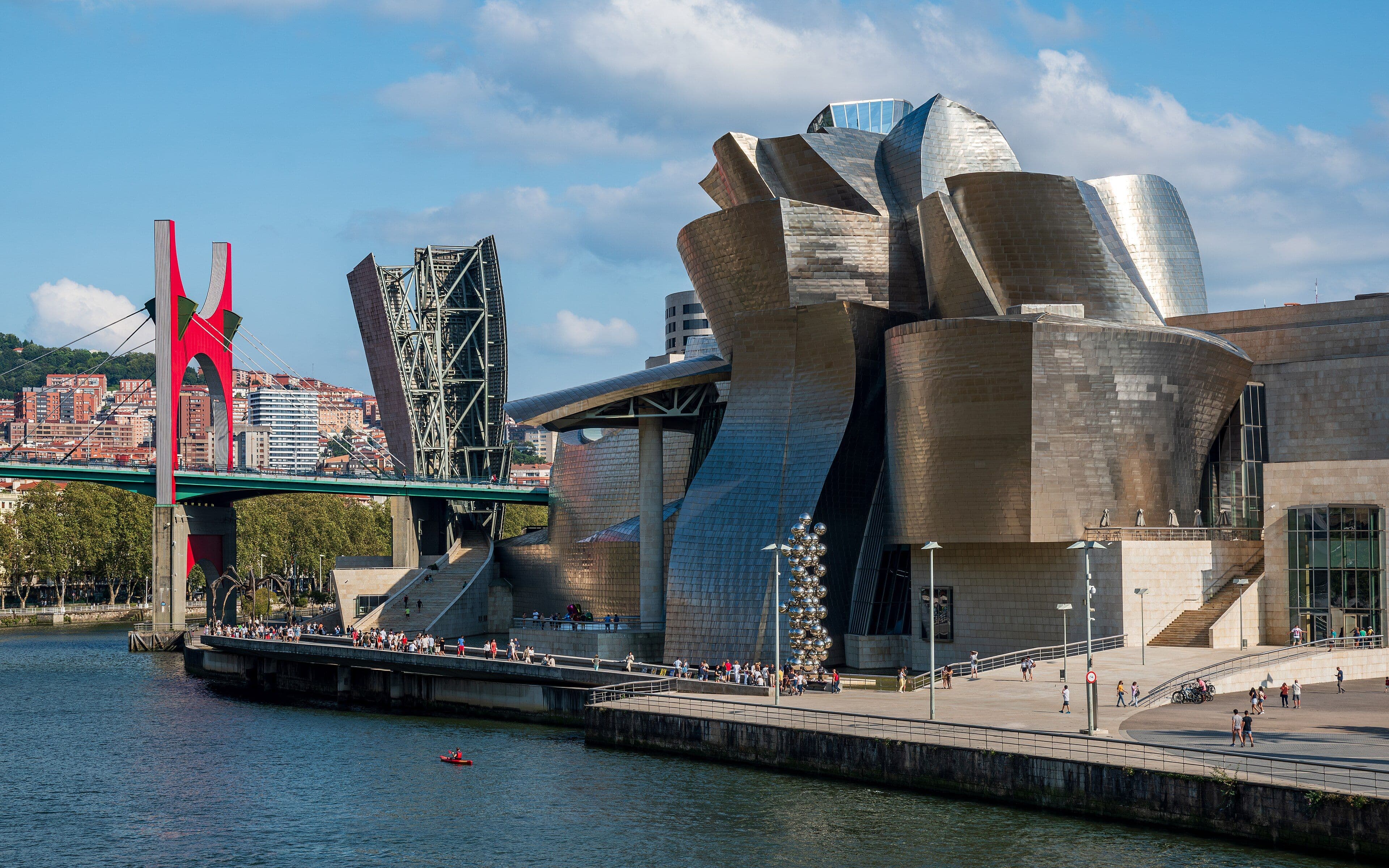 El Museo Guggenheim de Bilbao junto a la ría del Nervión, con el puente de La Salve a la izquierda